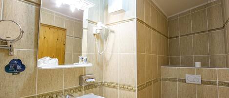 Un baño con lavamanos, espejo, inodoro y ducha.