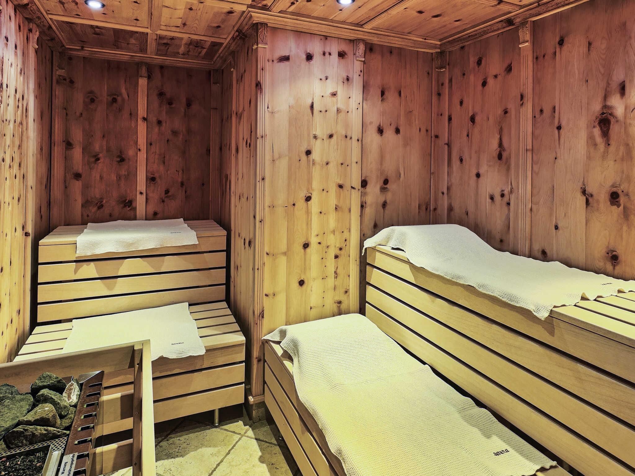 Una cabaña de madera con dos literas, cada una con una colcha blanca.