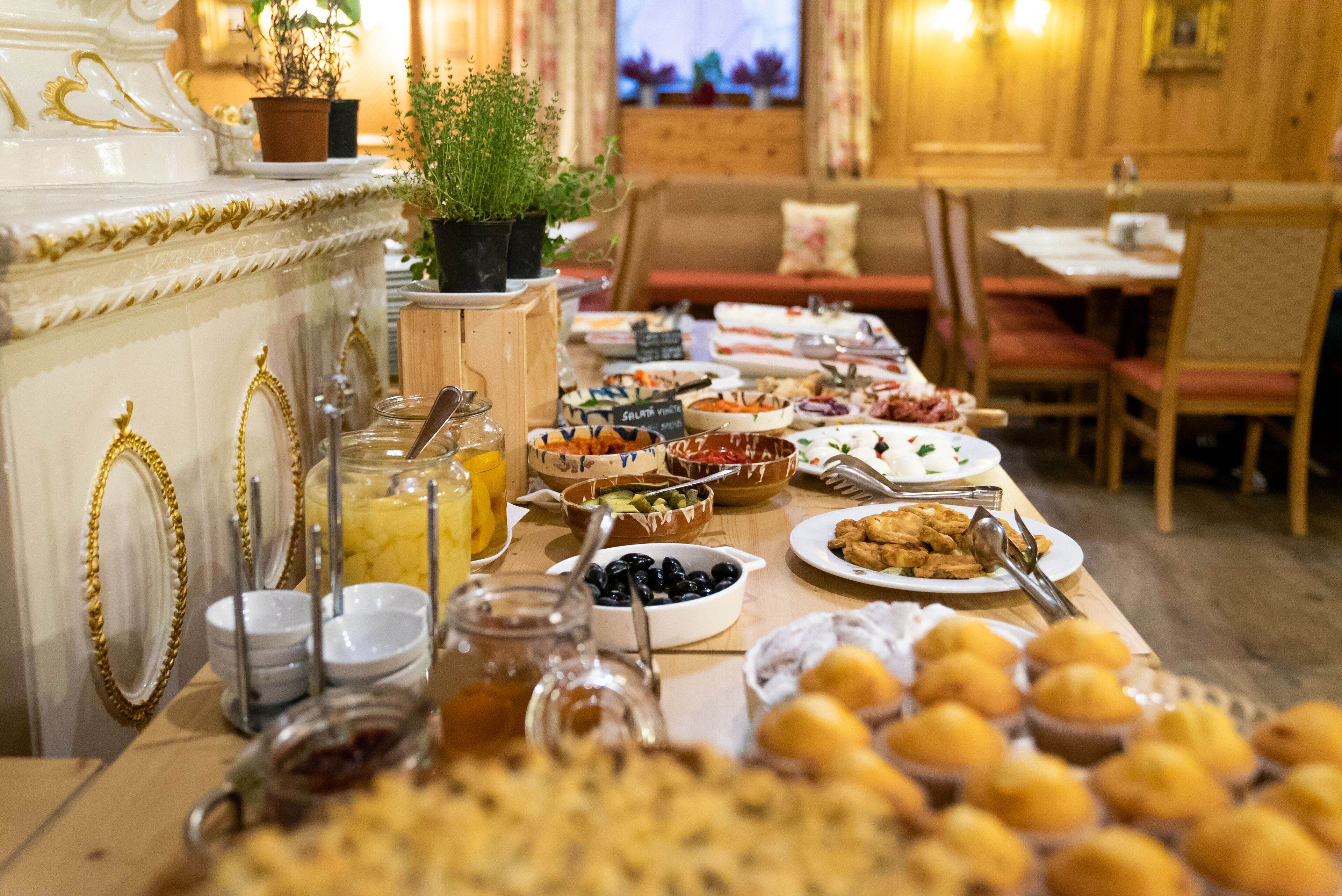 A buffet table with various food items and a decorative mirror.