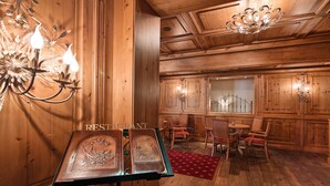 Un intérieur en bois comprenant un coin repas, des lustres et un présentoir à menus.