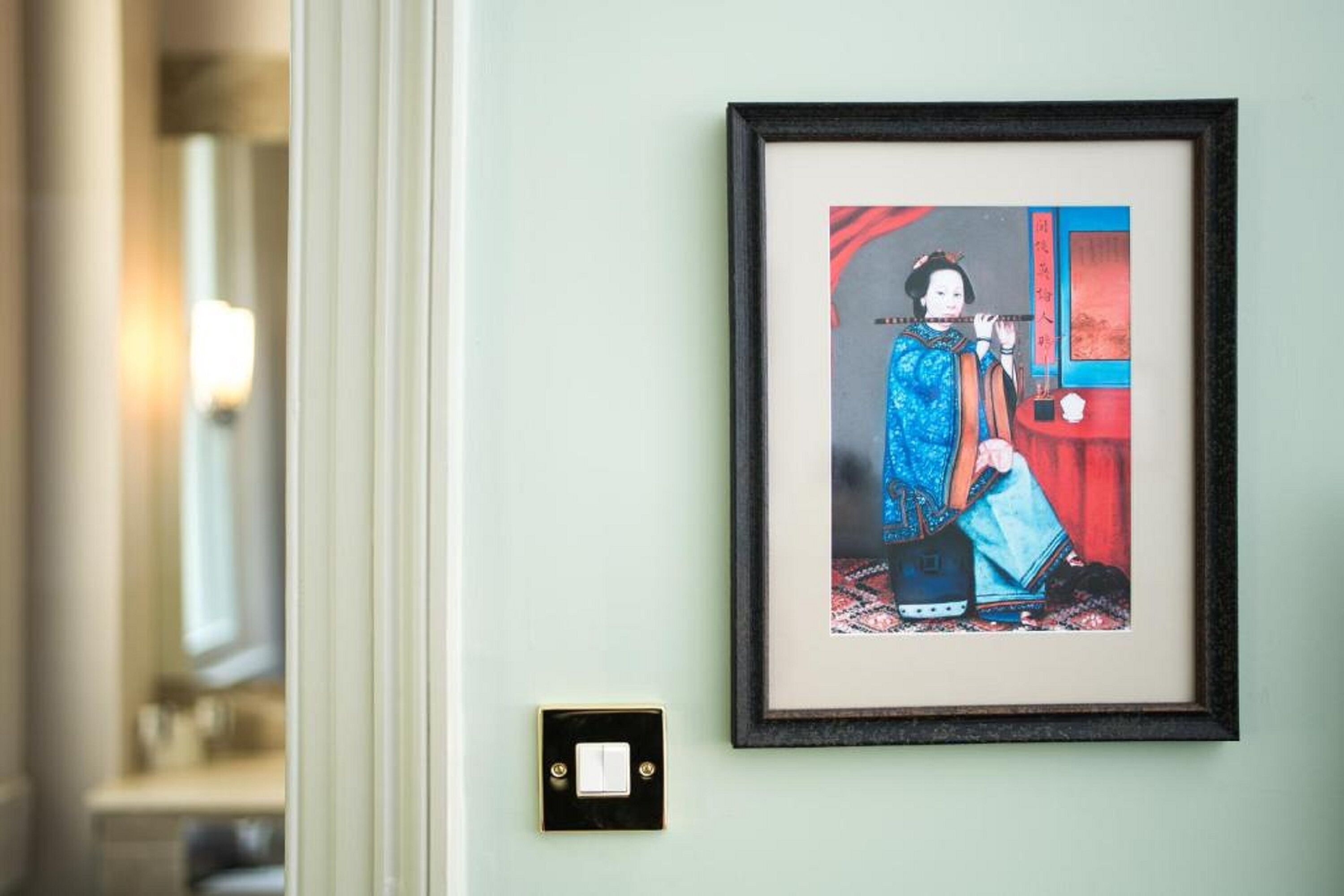 Uma obra de arte emoldurada em uma parede de um quarto de hotel.