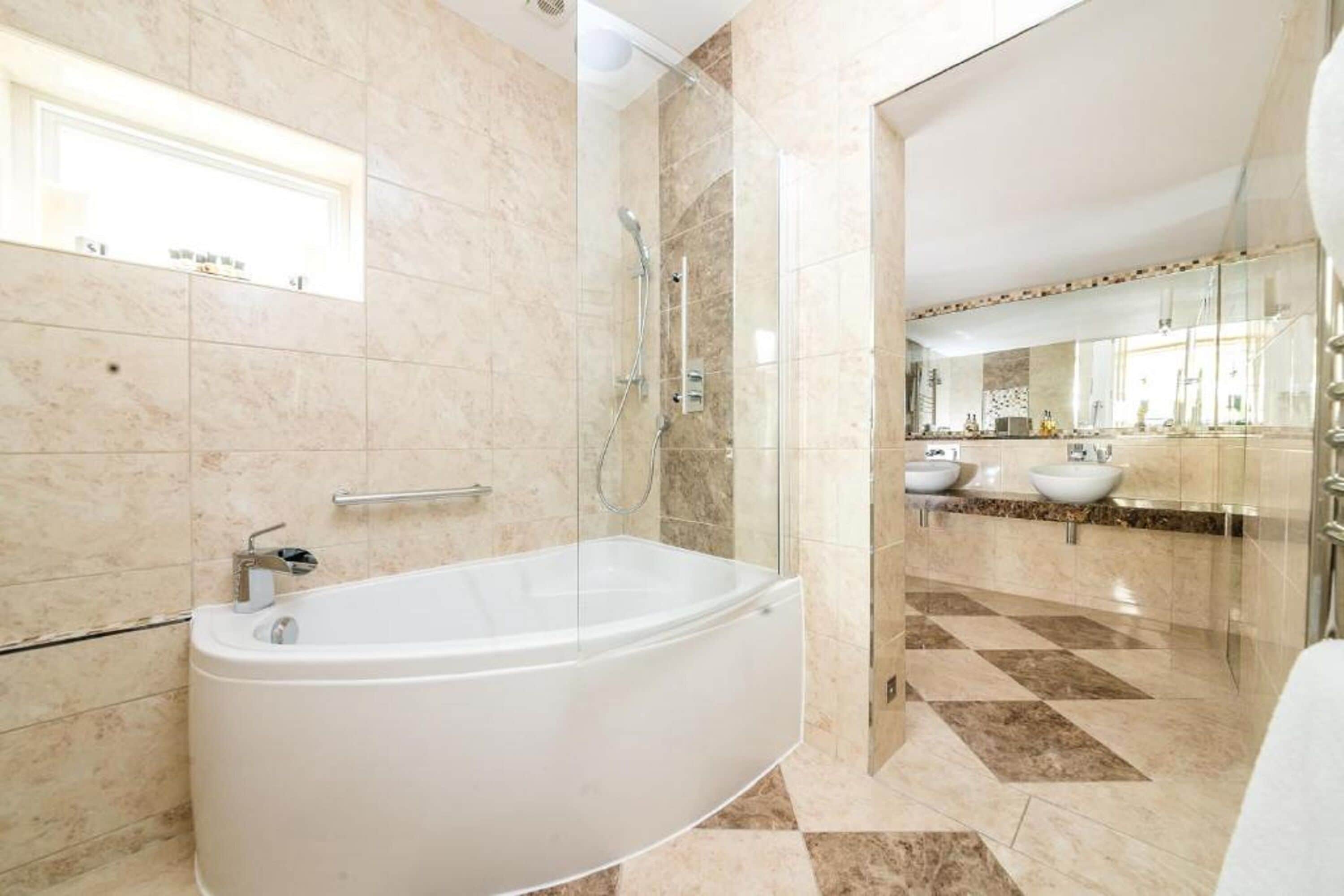 A modern bathroom with a freestanding bathtub, a glass shower enclosure, and a vanity with two sinks.