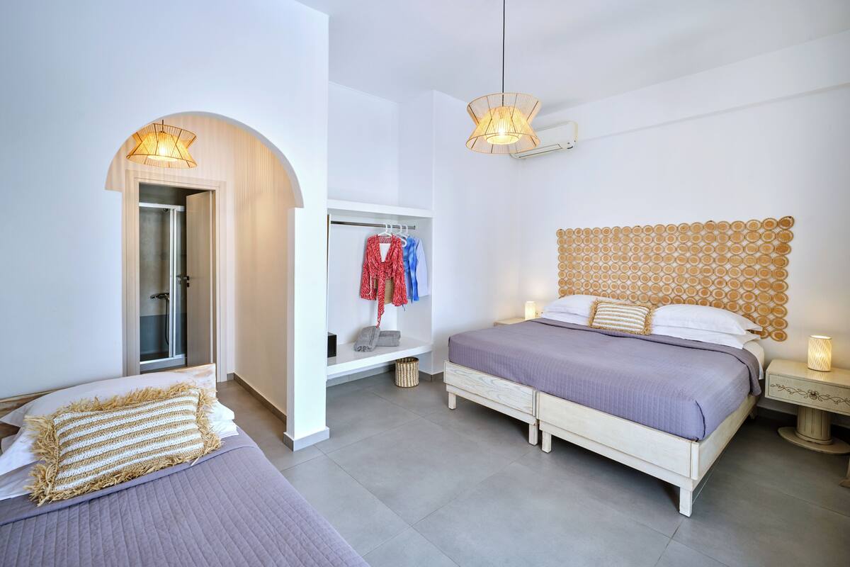 Une chambre moderne avec un grand lit, une armoire et une douche.