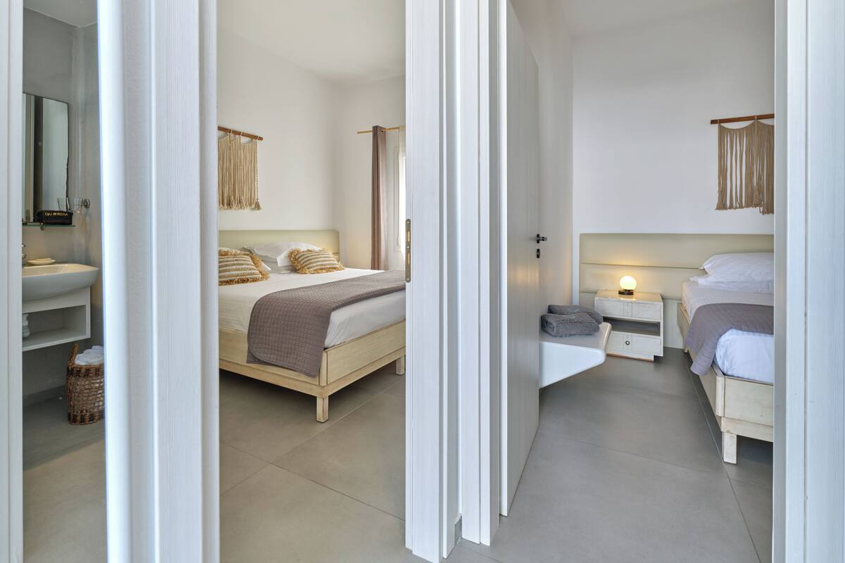 Une chambre moderne avec un grand lit, des tables de chevet, une commode et un miroir.