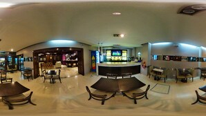 A spacious indoor area with multiple seating arrangements, a bar counter, and a variety of amenities. - Hotel Posadas (Posadas)