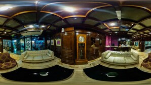 A luxurious lobby with a grand wooden reception desk, plush seating areas, and a large clock. - Hotel Posadas (Posadas)