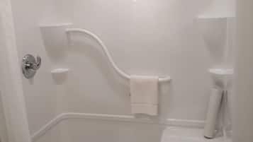 Une salle de bain blanche avec une douche, des toilettes et un porte-serviettes.