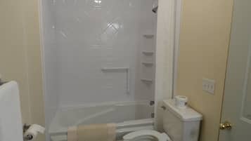 A bathroom with a shower, toilet, and a towel rack.