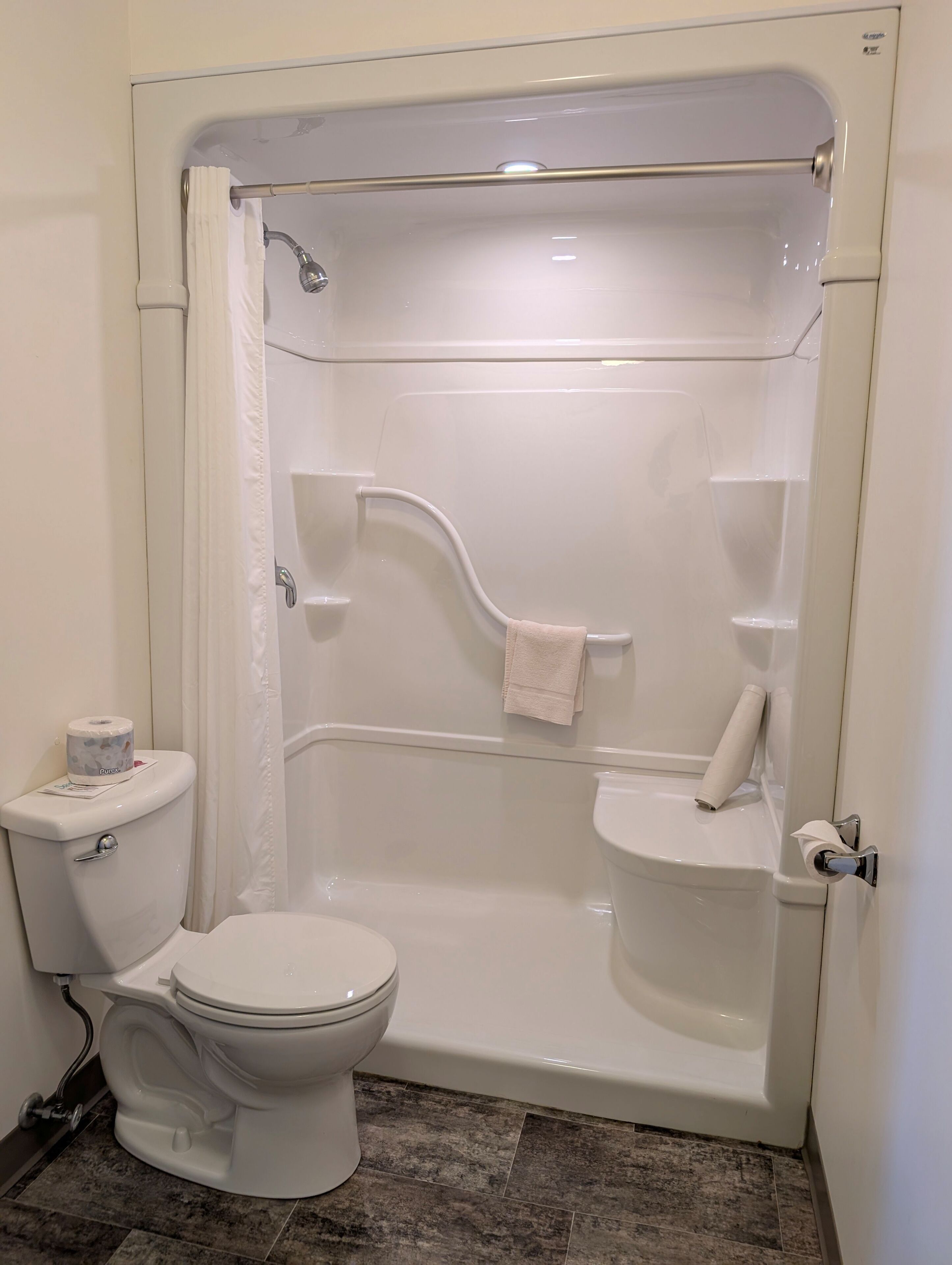 Een badkamer met toilet, bad en douchegordijn.