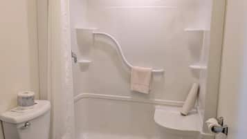 Een badkamer met toilet, bad en douchegordijn.