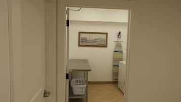 Een wasserette met een bord boven de deur, een klein tafeltje, een mand en een plank met opgevouwen handdoeken.