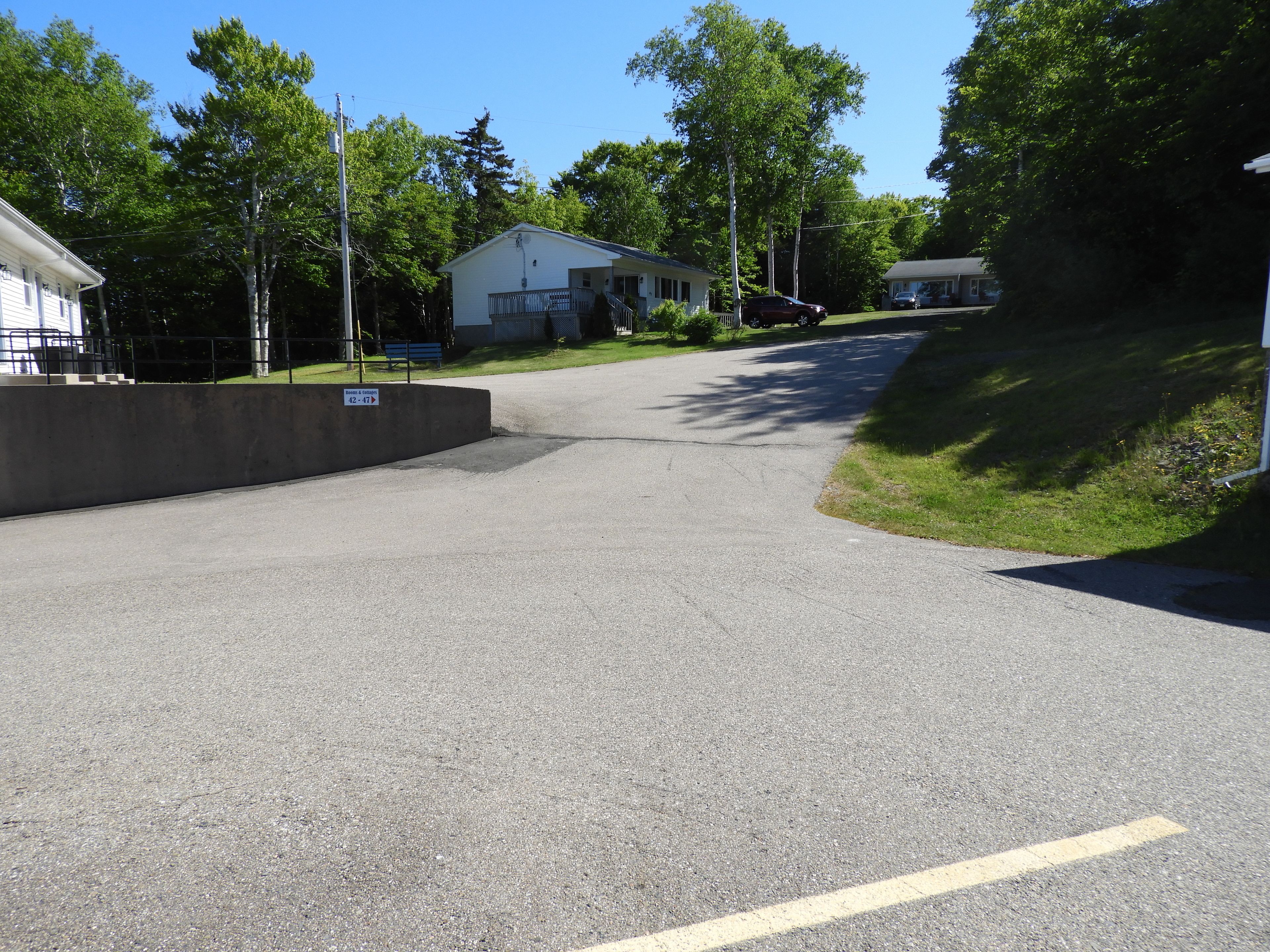 A residential street with houses, a sidewalk, and a curb.