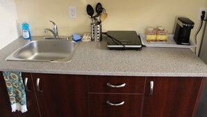 A kitchen with a stainless steel sink, a coffee maker, and a toaster. - Imperial Fireside Inn (Sudbury)