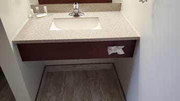 A bathroom with a sink, mirror, and a tissue box.