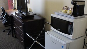 A hotel room with a desk, a computer, a microwave, and a refrigerator. - Imperial Fireside Inn (Sudbury)