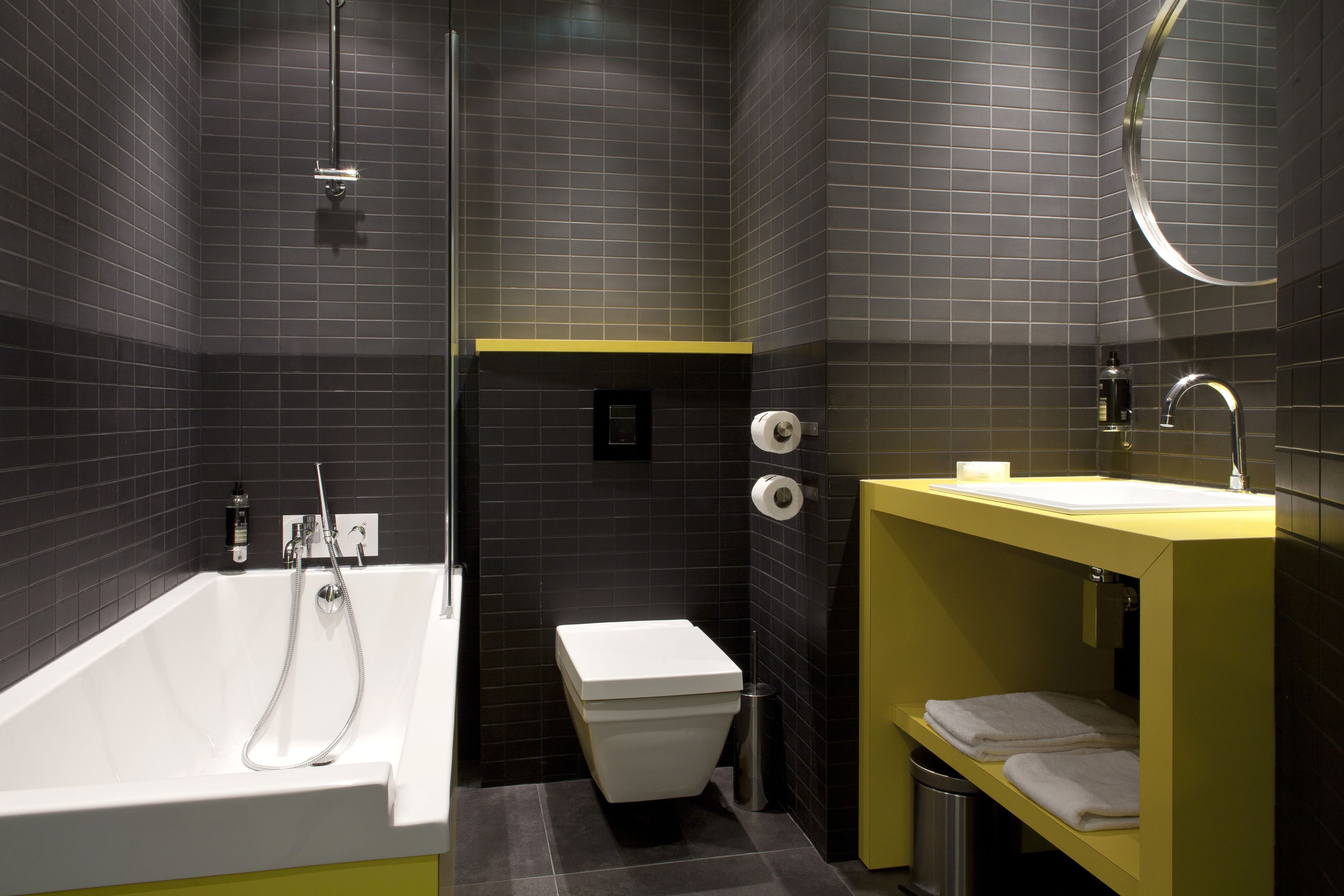 A modern bathroom with a bathtub, toilet, and sink.