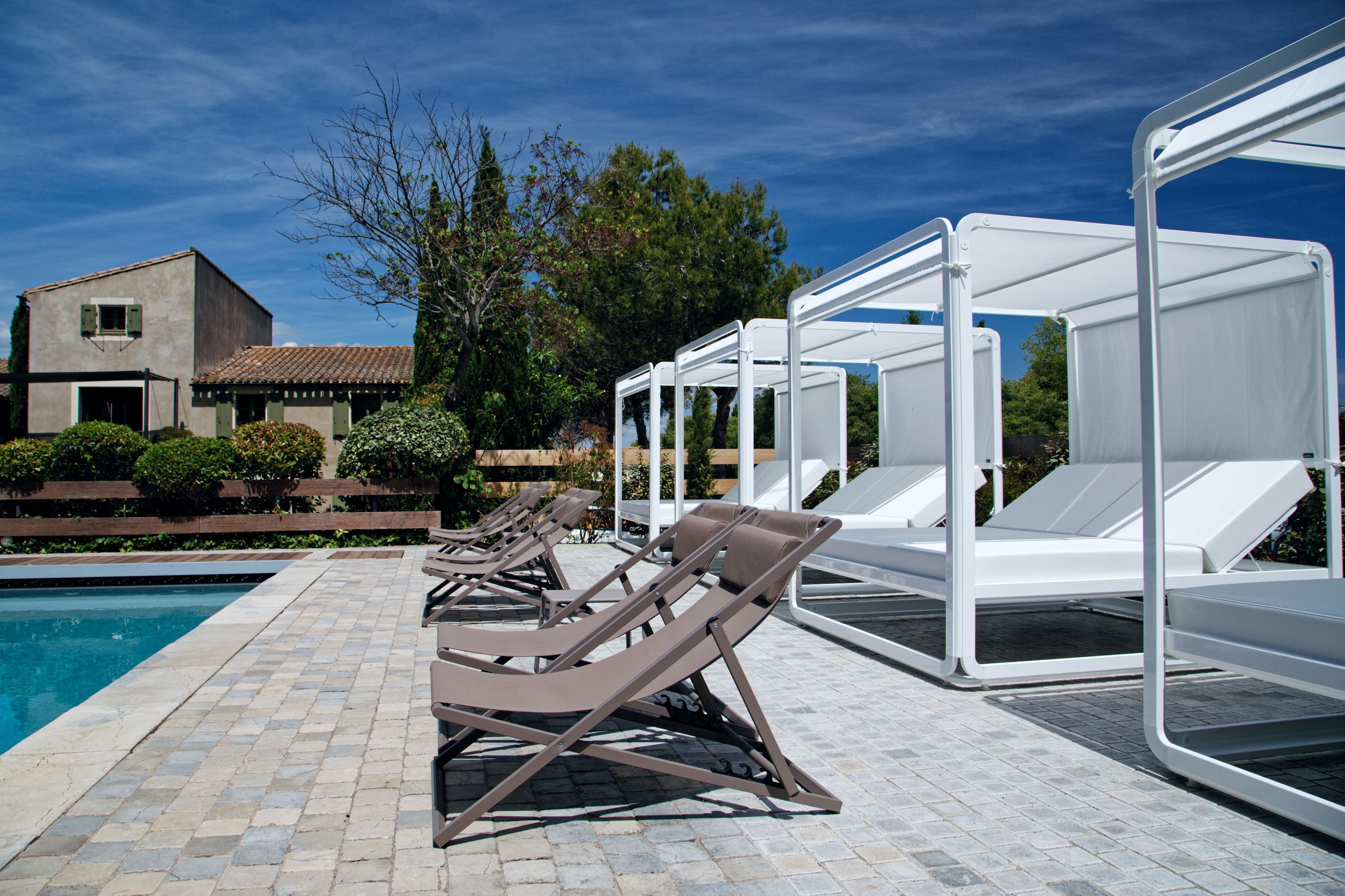A poolside area with lounge chairs and a covered seating area.