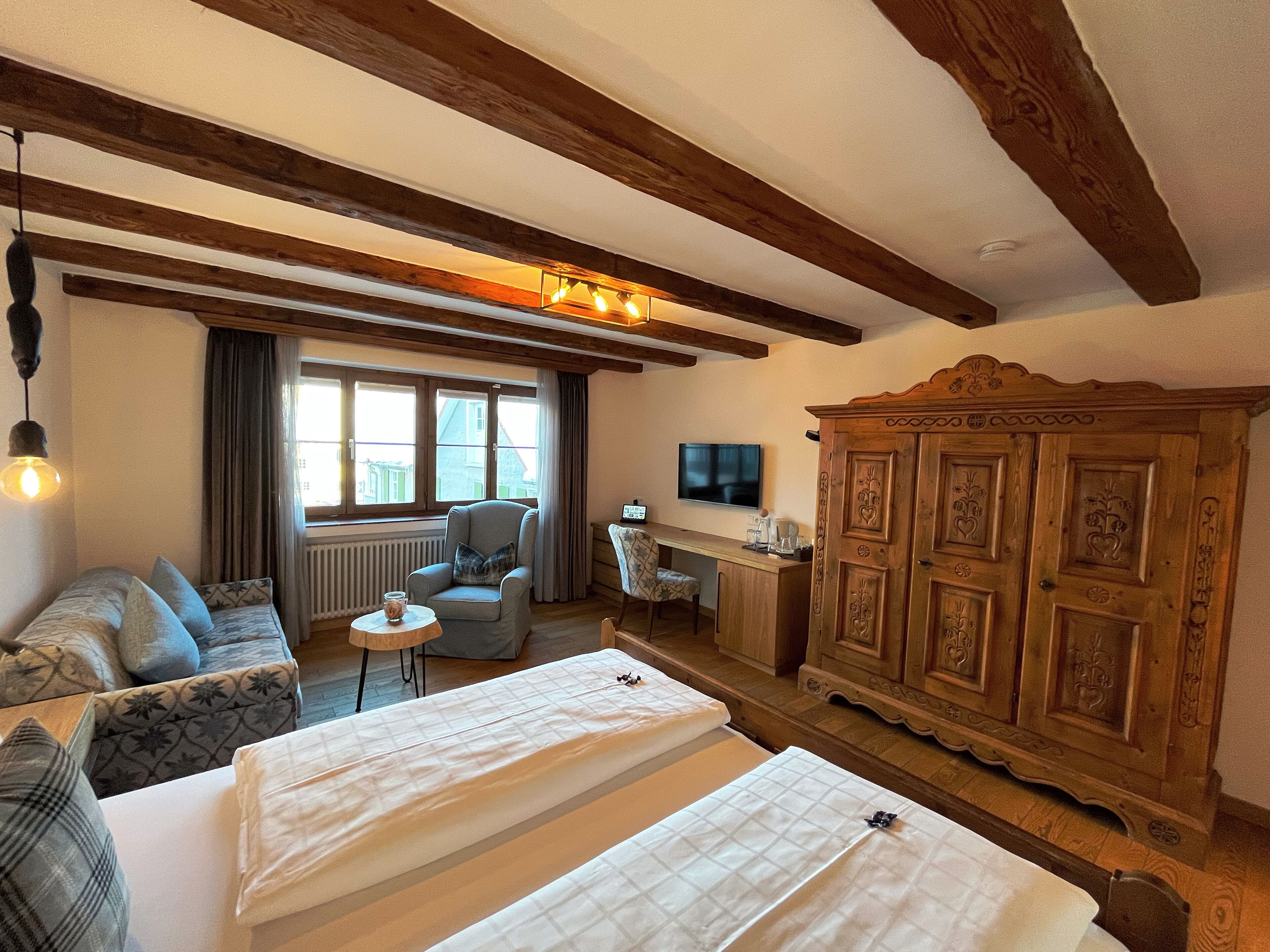 Une chambre d’hôtel comprenant un lit, un canapé, un bureau et une armoire.