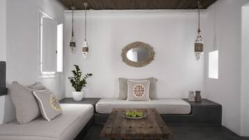 Ein stilvolles Wohnzimmer im minimalistischen Stil mit einer Couch, einem Couchtisch und hängenden Dekorationen.