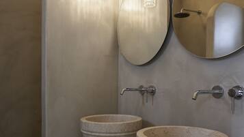 A bathroom with two large marble sinks, a mirror, and a pendant light.