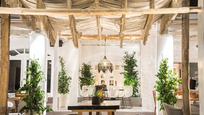 A dining area with a central table, chairs, and a hanging light fixture. - Makris Beach Hotel (Santorini)