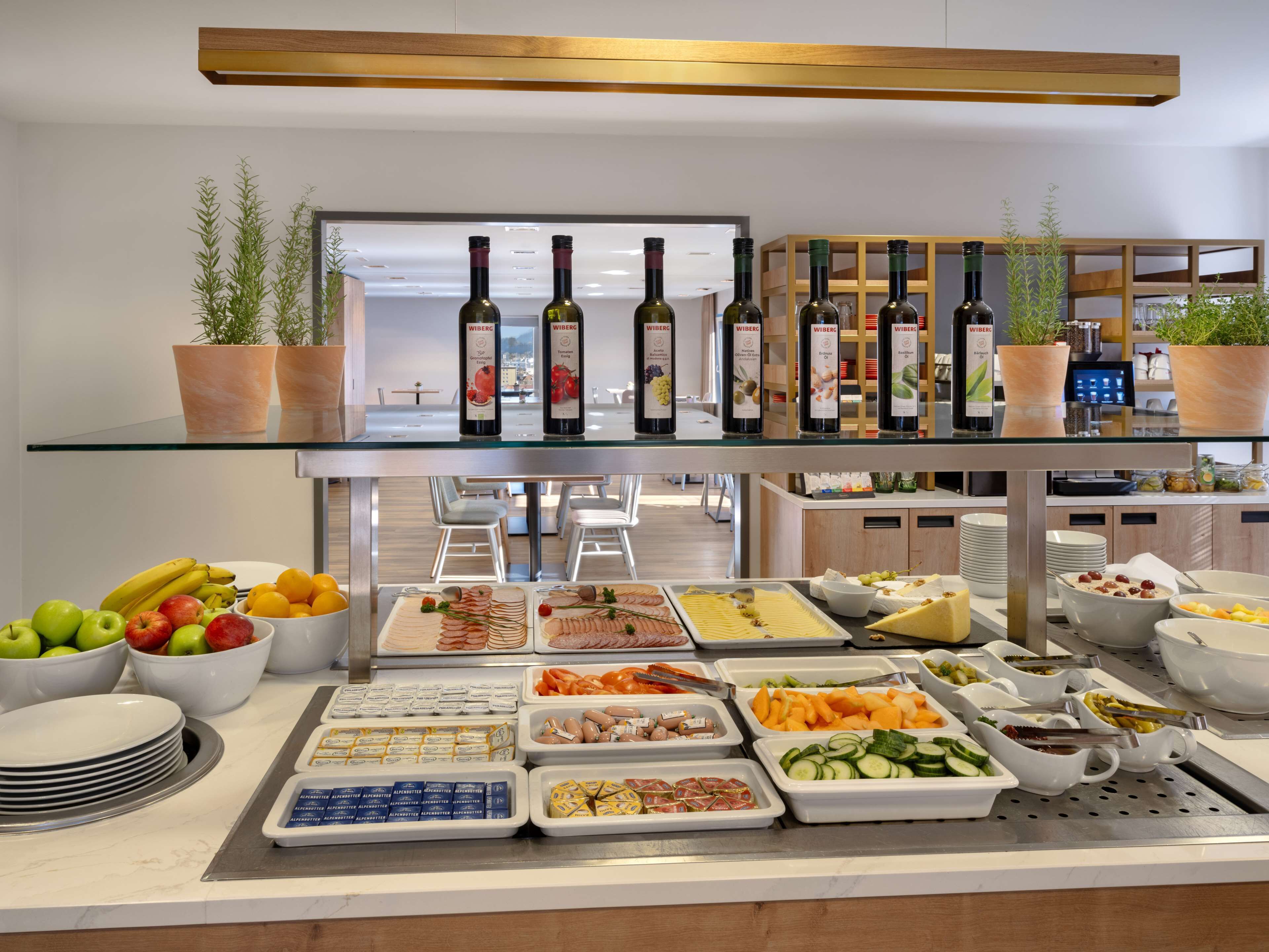 A buffet with various food items and wine bottles.