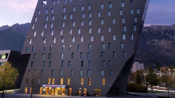 Een modern hotel met een uniek, hoekig ontwerp, met meerdere verdiepingen en een opvallende entree.