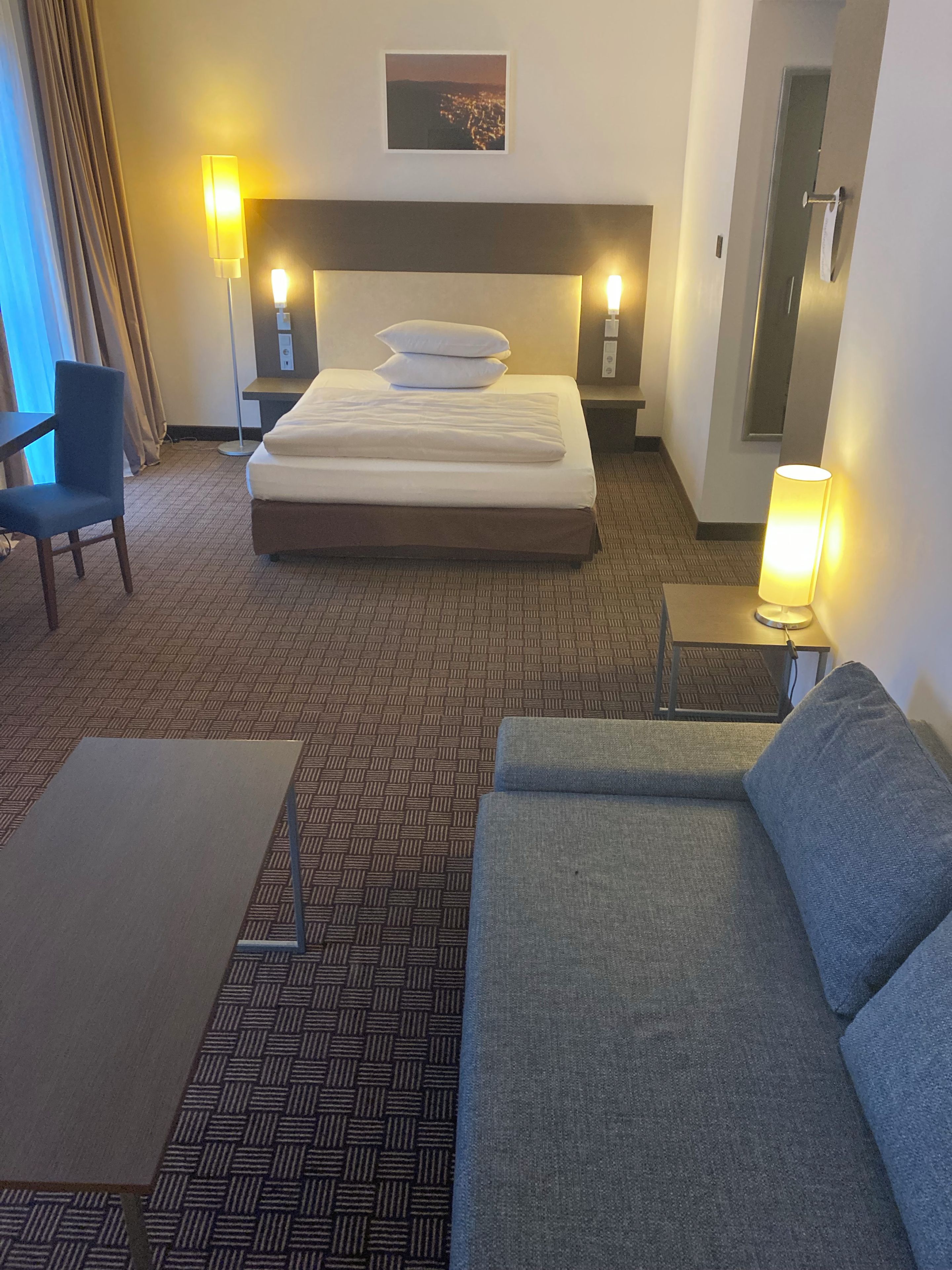 Una habitación de hotel con una cama, un sofá, un escritorio y una silla.