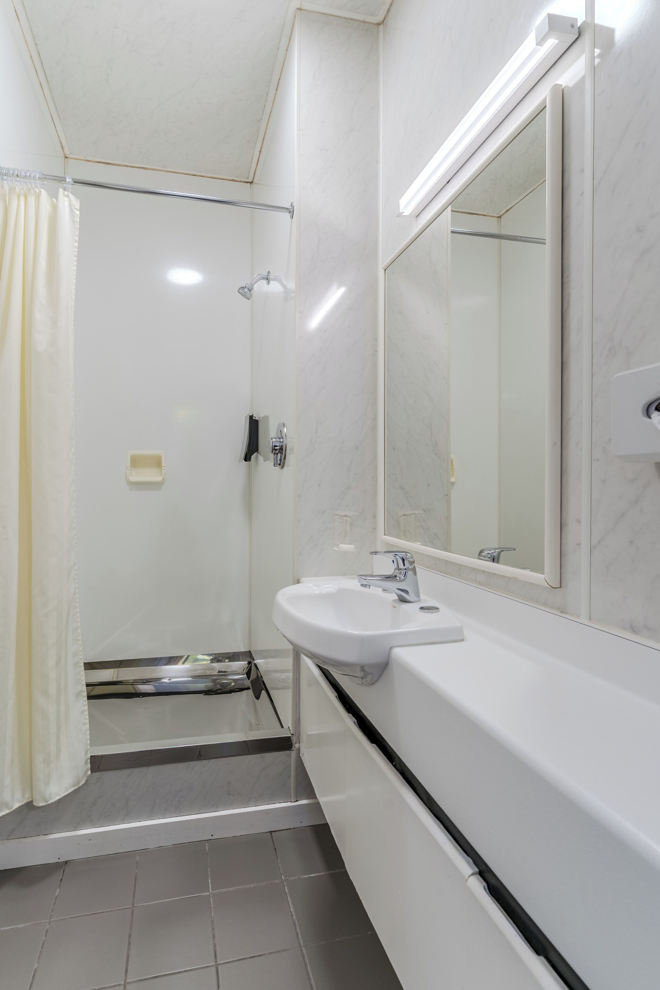 Un baño moderno con ducha, inodoro y lavabo.