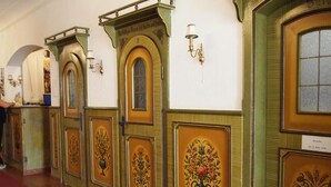 Un pasillo con puertas ornamentadas y apliques en la pared.