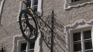 Fachada de edificio con múltiples ventanas, cada una con marcos blancos y una superficie de pared texturizada.