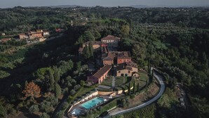 An aerial view of a villa with a swimming pool, surrounded by lush greenery and terraced gardens. - Borgo Di Colleoli Resort (Palaia)