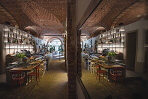 A restaurant with brick ceilings, glass bar counters, and multiple seating areas. - Borgo Di Colleoli Resort (Palaia)