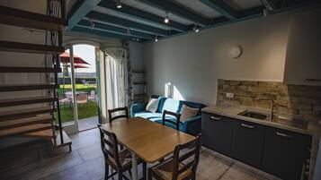 Une cuisine moderne avec un coin repas, un escalier et une vue sur l’extérieur.