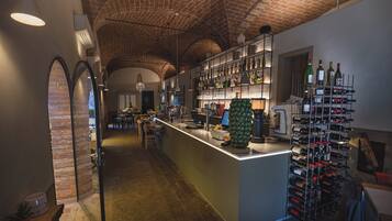 A bar area with a brick ceiling, a wine rack, and a counter with a computer.