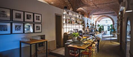 A restaurant with brick ceilings, a bar area, and framed pictures on the walls.