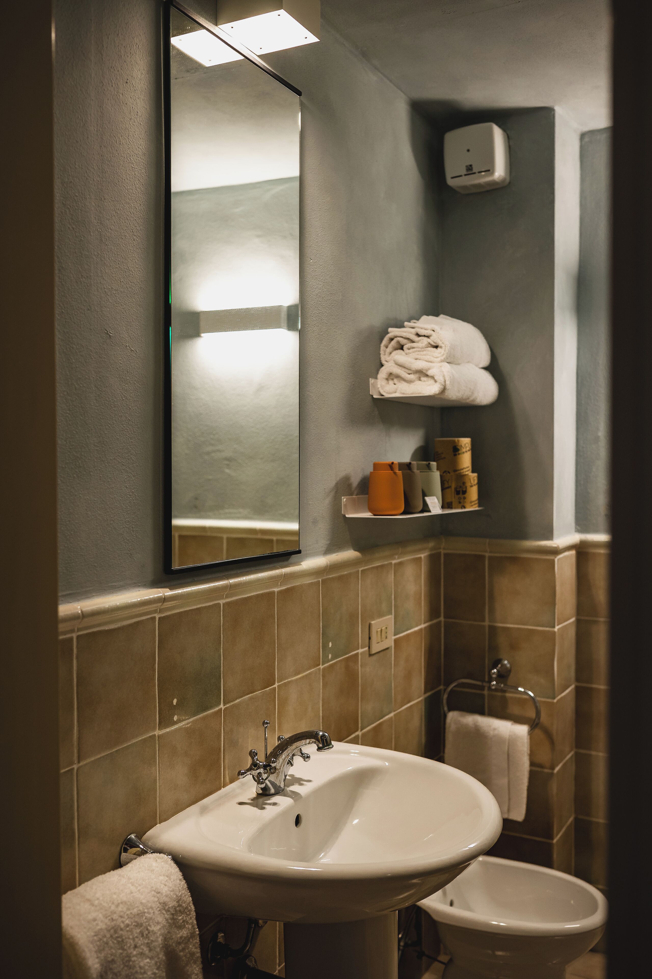 A bathroom with a sink, mirror, and towel rack.