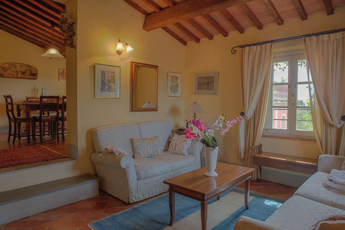 Una sala de estar acogedora con un sofá, una mesa de centro y un comedor con sillas y una mesa.