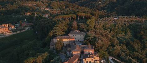 An aerial view of a large estate with multiple buildings, a swimming pool, and a well-maintained garden.