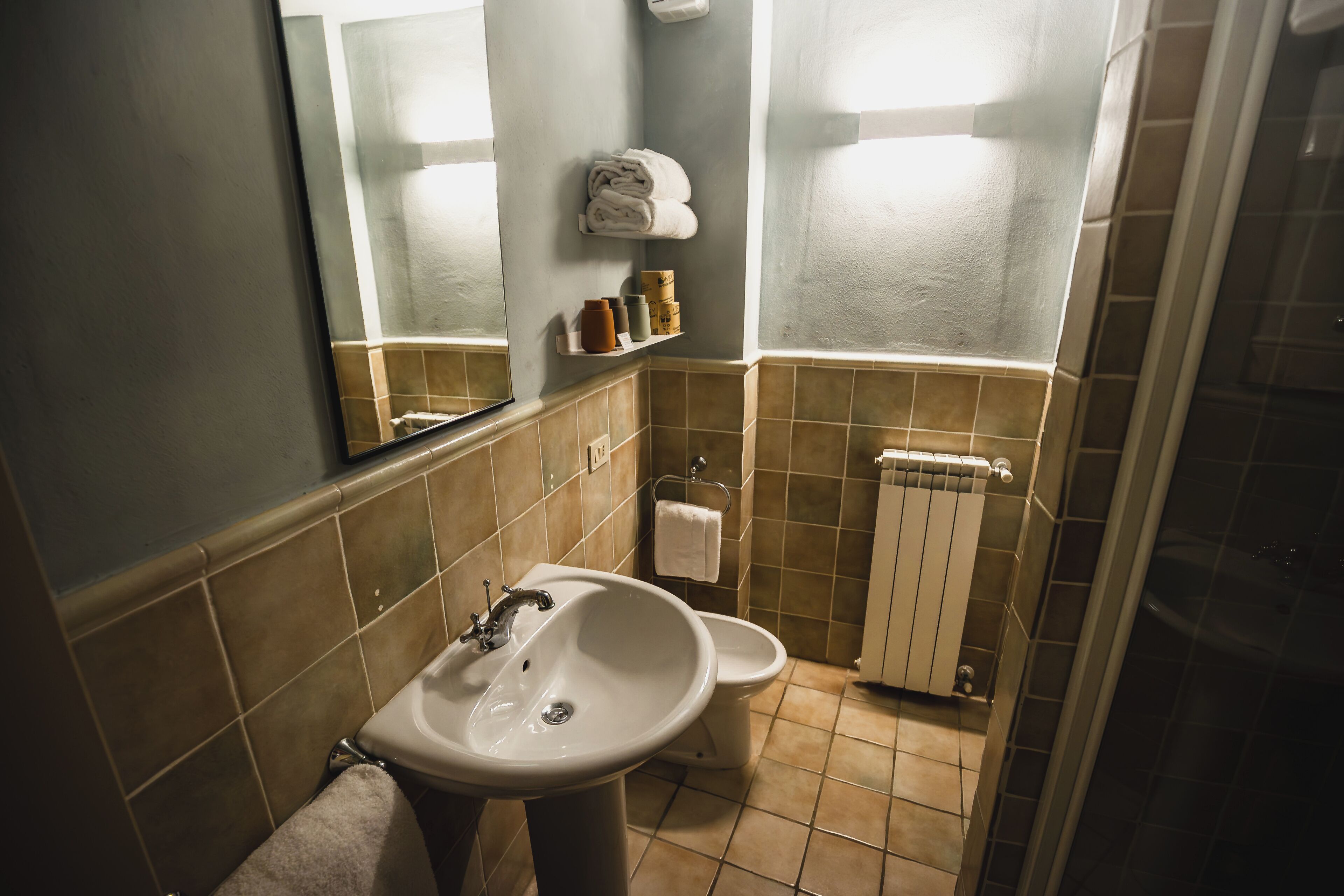 Un baño con lavamanos, inodoro y un perchero para toallas.
