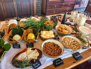 A buffet table with various food items including cheese, almonds, and herbs. - Kleinkaap Boutique Hotel (Centurion)