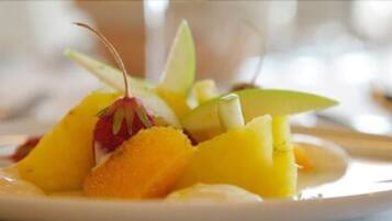 Una ensalada de frutas con rodajas de manzana y gajos de naranja.