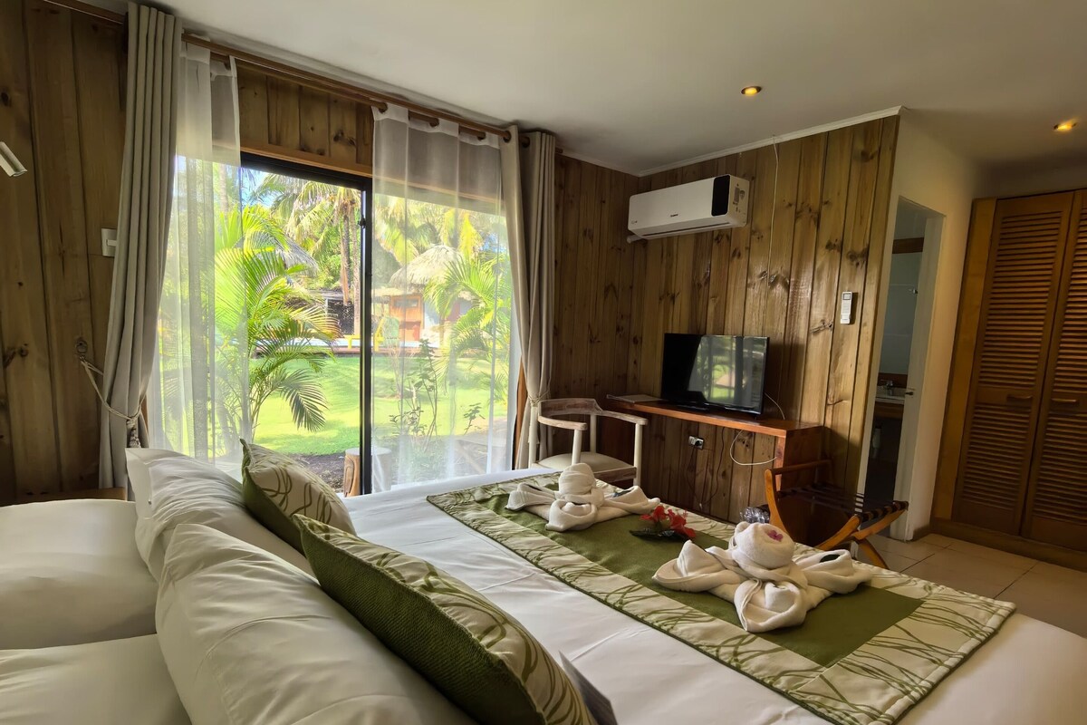 Habitación de hotel con una cama grande, un escritorio y televisión.