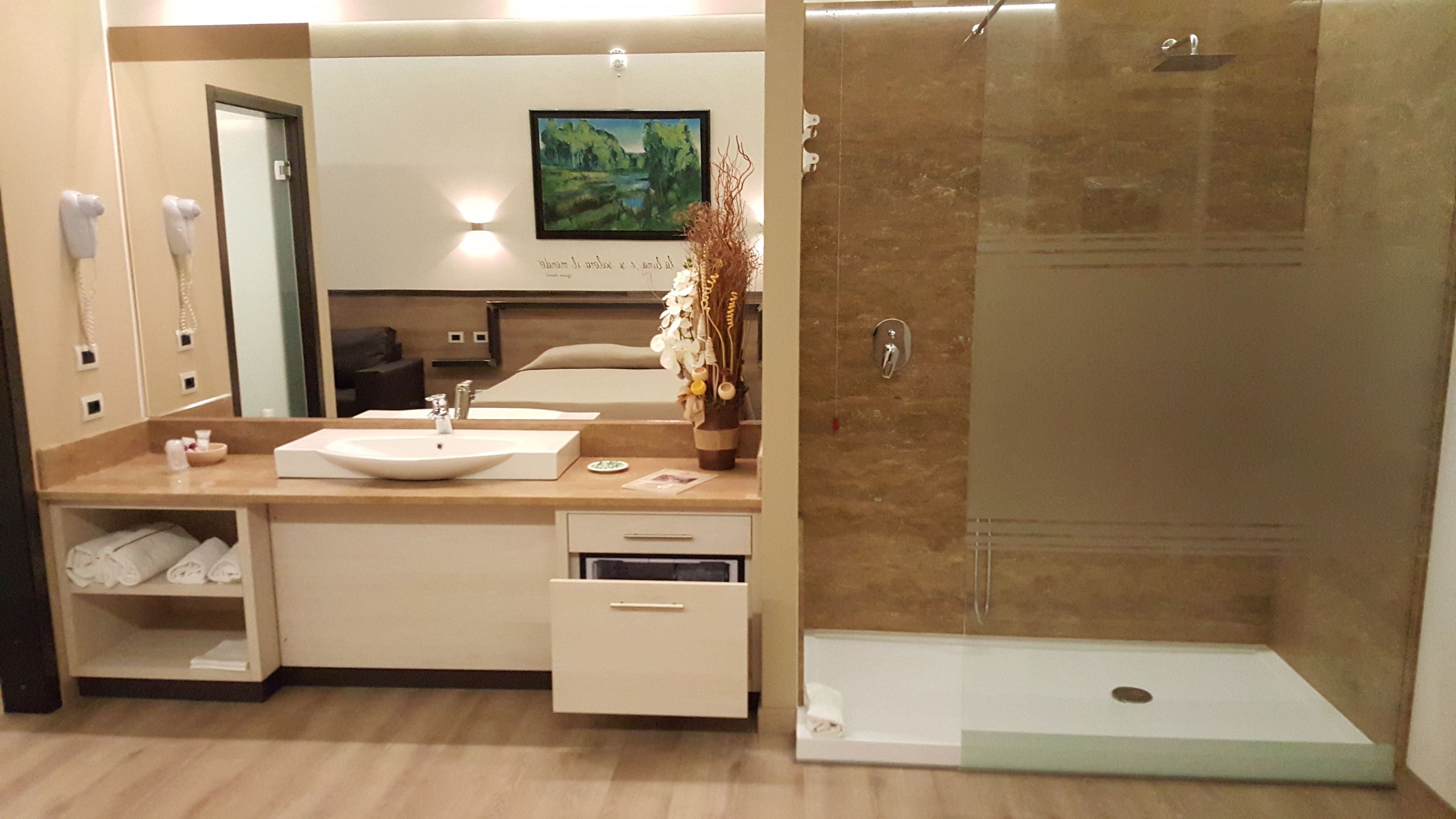 A modern bathroom with a sink, mirror, and shower.