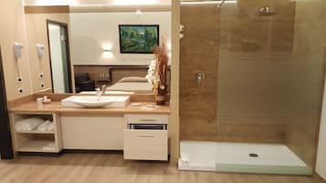 A modern bathroom with a sink, mirror, and shower.