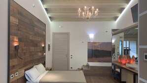 Un dormitorio moderno con cabecera de madera, una cama grande, una araña y un cuadro de una puesta de sol.