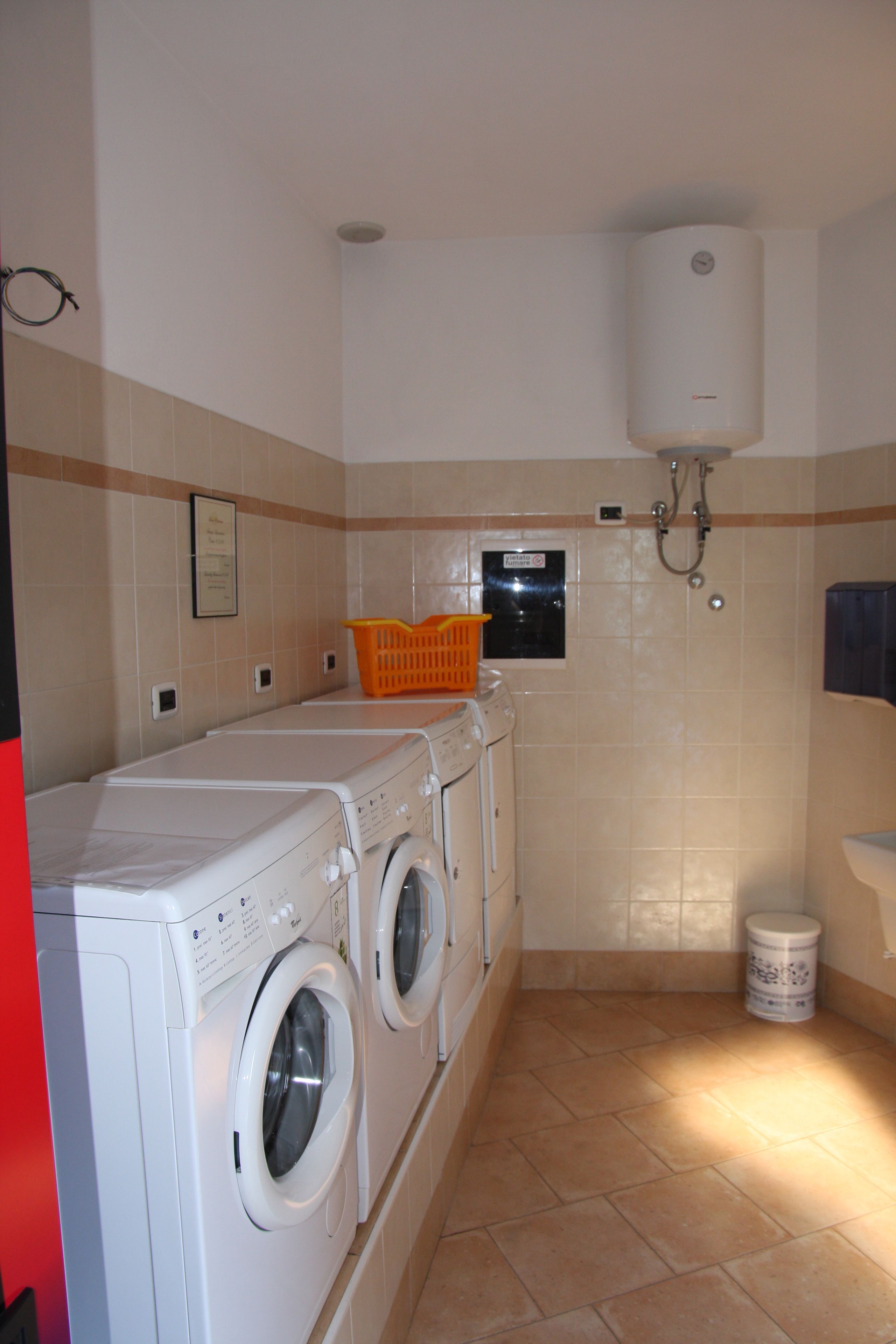 Zona de bugaderia amb rentadora, assecadora i una finestra petita.