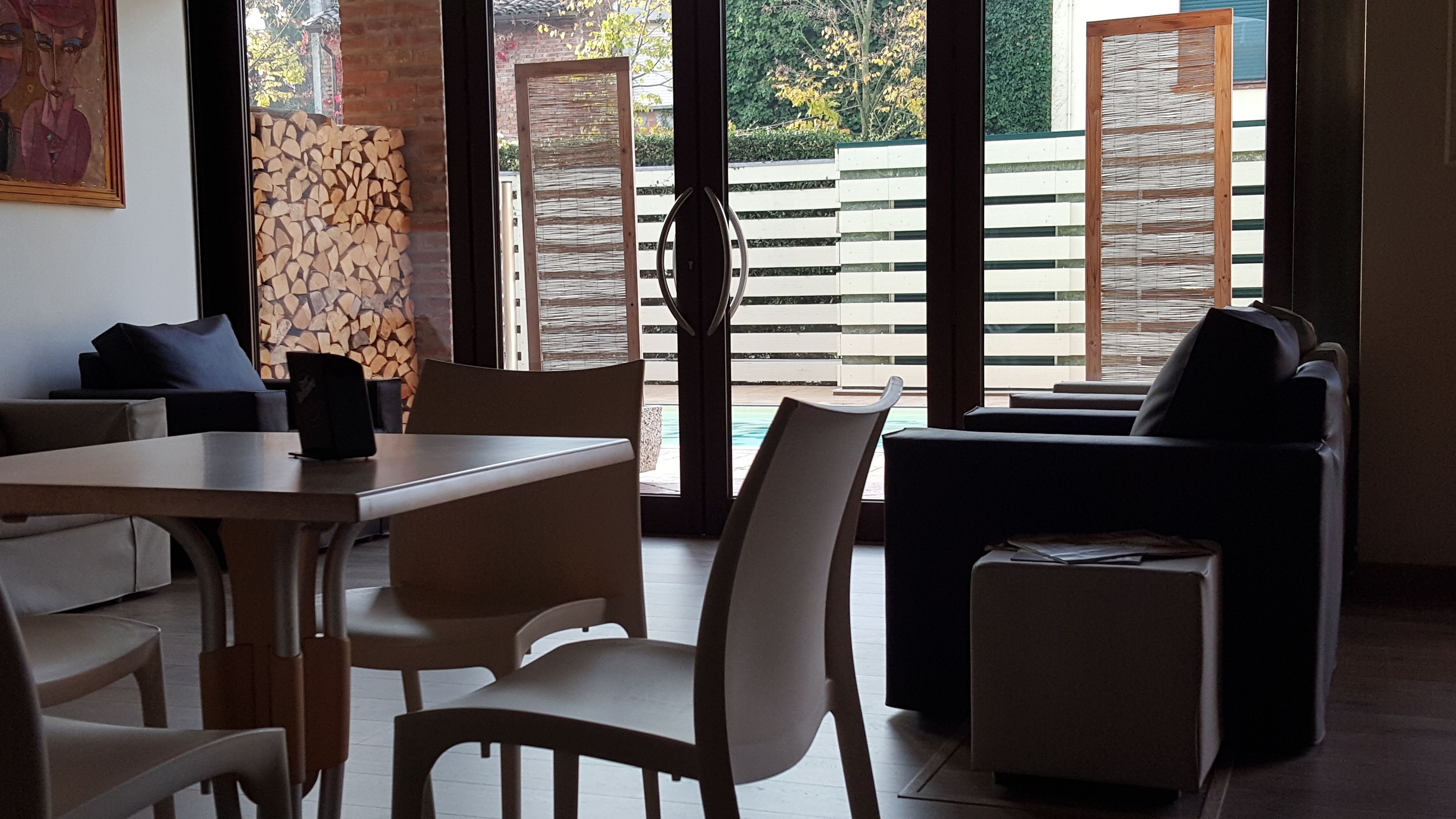 Ein modernes Wohnzimmer mit Essbereich, Kamin und Blick auf Pool und Garten.