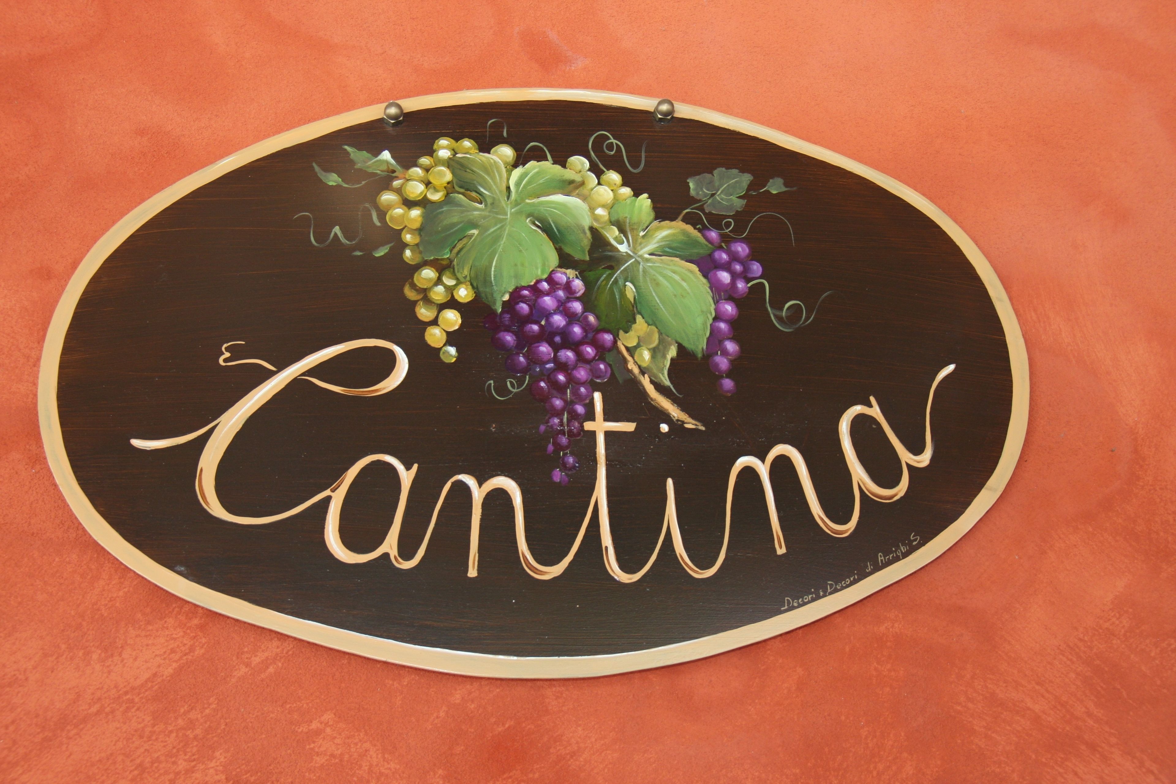 A wooden sign with the name "Cantina" and grape illustrations.