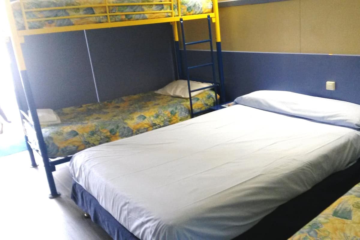Un dormitorio con literas y una cama individual.